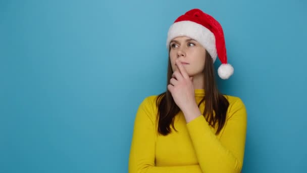 귀여운 여성은 아이디어 동작으로 손가락을 치켜들고 스웨터를 크리스마스 빨간색 모자를 — 비디오