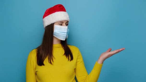 크리스마스 빨간색 모자를 여성은 코로나 바이러스로부터 자신을 보호하기 인공호흡기 마스크를 — 비디오