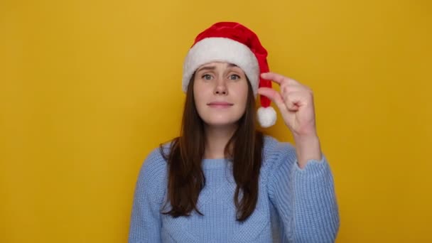 Junge Frau Zeigt Winzigen Gegenstand Formt Etwas Kleines Trägt Weihnachtsmütze — Stockvideo