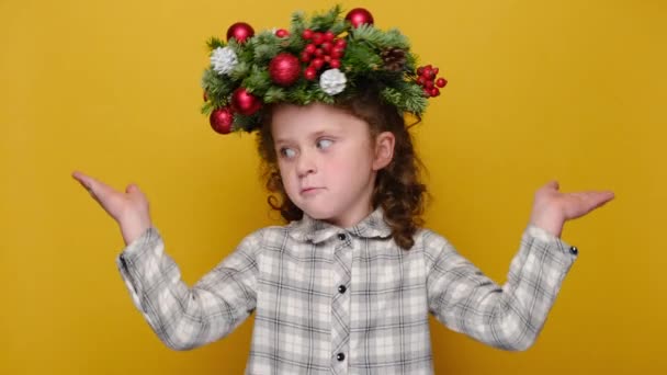 Emotivní Malé Dítě Tradičním Vánočním Věnci Pokrčí Rameny Vypadá Nejistě — Stock video