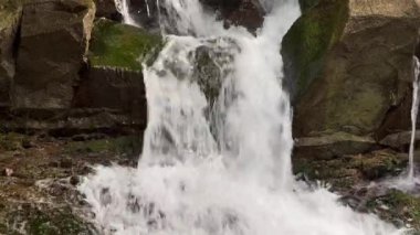 Güneşli yaz gününde küçük bir dağ şelalesine yakın. Kristal berrak su. Sakin doğal merak, yeşil turizm konsepti için sessiz bir yer