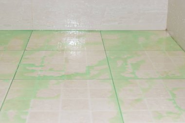 Kirli banyoda yerde derin lekeler ile. Temizlik için sıvı yeşil dökme .