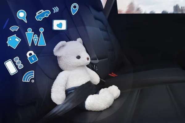 Speelgoed Beer wit vastgemaakt met veiligheidsgordel op de achterbank van de auto en rechts lege ruimte voor tekst. Concept en bescherming van kinderen. — Stockfoto