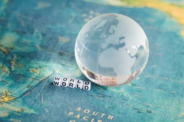 Globo de cristal e mapa do mundo com "WORLD" alfabeto cubo letra — Fotografia de Stock