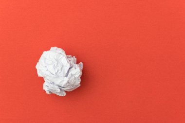 İş konsepti için kırmızı arka plan üzerinde buruşuk kağıt topu.