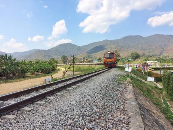Moutian manzara kırsal Lampang Eyaleti Kuzey Tayland at ile metal demiryolu üzerinde çalışan tren.