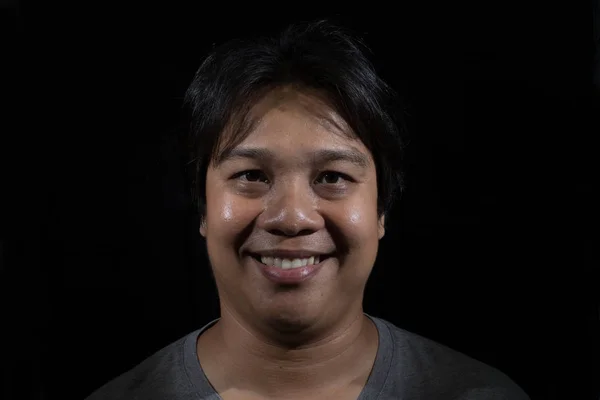 Stüdyo siyah arka planda gülümseyen bir erkek portre