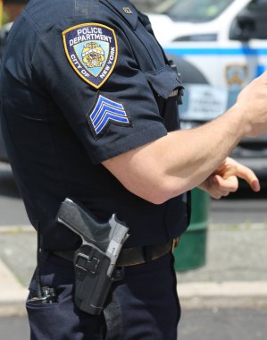 BROOKLYN, NEW YORK - MAY 20, 2018: NYPD police officer provides security during Bay Fest street festival on Sheepshead Bay in Brooklyn clipart