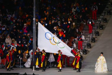 PYEONGCHANG, SOUTH KOREA - FEBRUARY 9, 2018: The Olympic flag raising ceremony at PyeongChang Olympic Stadium during the 2018 Winter Olympics Opening Ceremony clipart