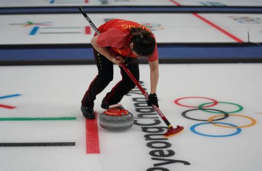 Tarihleri, Güney Kore - 10 Şubat 2018: Rui Wang Çin'in karışık çiftler hepsini bir kez deneme kıvırma maçında 2018 Kış Olimpiyatları'nda yarışmaktadır