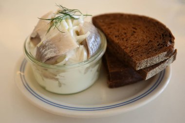 Çavdar ekmeği ile soğan turşusu ve krema sosu ile salamura ringa balığı filetosu 