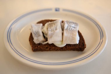 Çavdar ekmeği ile soğan turşusu ve krema sosu ile salamura ringa balığı filetosu 