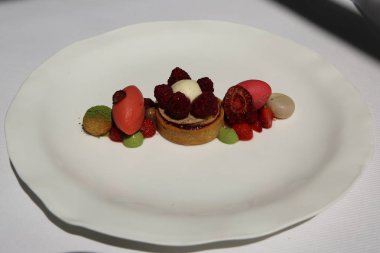 Tatlı gurme Fransız restoranında. Çilek ve ahududu ile ahududu badem tartı Sorbets, Matcha profiterol, Pazar çilek 