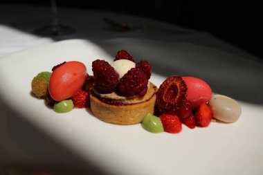 Tatlı gurme Fransız restoranında. Çilek ve ahududu ile ahududu badem tartı Sorbets, Matcha profiterol, Pazar çilek 