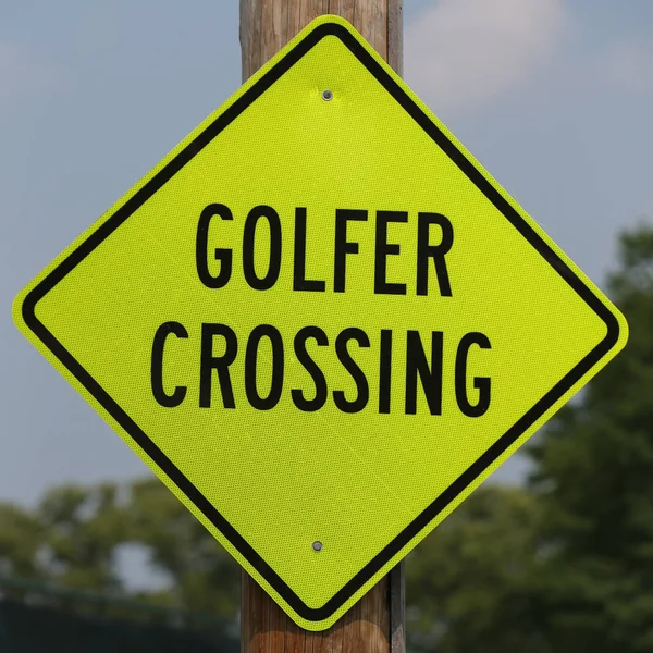 Golfer crossing street sign