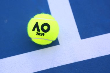 MELBOURNE, AUSTRALIA - JANUARY 23, 2019: Dunlop tennis ball with Australian Open logo on tennis court at Australian tennis center in Melbourne Park  clipart
