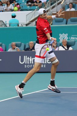 Miami Gardens, Florida-27 Mart, 2019: ABD 'nin profesyonel tenis oyuncusu John Isner, Miami Gardens, Florida 'daki Hard Rock Stadı 'nda 2019 Miami Open 'ta çeyrek final maçında eylem yapıyor