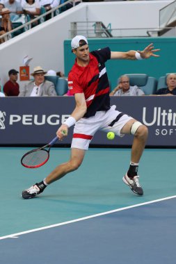 Miami Gardens, Florida-27 Mart, 2019: ABD 'nin profesyonel tenis oyuncusu John Isner, Miami Gardens, Florida 'daki Hard Rock Stadı 'nda 2019 Miami Open 'ta çeyrek final maçında eylem yapıyor