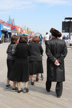 Brooklyn, New York - 23 Nisan 2019: Yahudi ortodoks ailesi Brooklyn, New York'taki Coney Adası'nda Hamur Burada Hamur İzinde