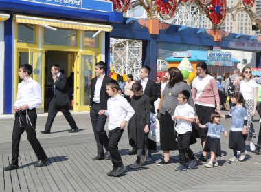 Brooklyn, New York - 23 Nisan 2019: Yahudi ortodoks ailesi Brooklyn, New York'taki Coney Adası'nda Hamur Burada Hamur İzinde