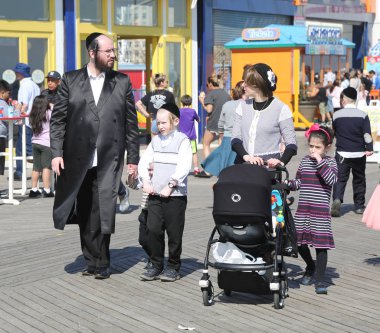 Brooklyn, New York - 23 Nisan 2019: Yahudi ortodoks ailesi Brooklyn, New York'taki Coney Adası'nda Hamur Burada Hamur İzinde