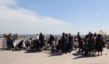 Brooklyn, New York - 23 Nisan 2019: Yahudi ortodoks ailesi Brooklyn, New York'taki Coney Adası'nda Hamur Burada Hamur İzinde