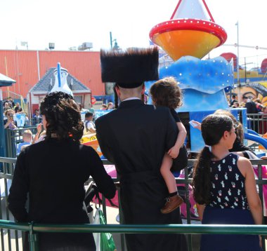 Brooklyn, New York - 23 Nisan 2019: Yahudi ortodoks ailesi Brooklyn, New York'taki Coney Island Luna Park'ta Hamur Burada Hamur Burada