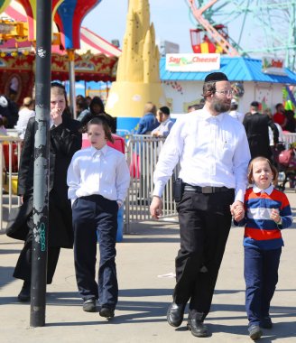 Brooklyn, New York - 23 Nisan 2019: Yahudi ortodoks ailesi Brooklyn, New York'taki Coney Island Luna Park'ta Hamur Burada Hamur Burada