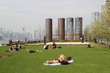 Brooklyn, New York - 2 Mayıs 2019: Turistler ve New Yorklular Williamsburg, Brooklyn'deki Domino Park'ta güneşli bir günün tadını çıkarıyor