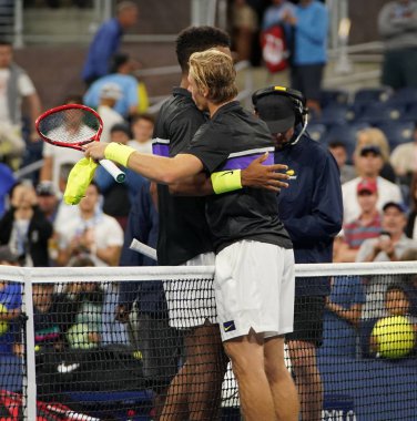 New York - 27 Ağustos 2019: Kanadalı profesyonel tenisçi Dennis Shapovalov, 2019 US Open ilk tur maçında kazandığı zaferin ardından Felix Auger Aliassime 'yi kucakladı. 