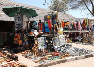 Hwange, ZIMBABWE - 3 Ekim 2018 Zimbabwe tarafındaki Victoria Falls Ulusal Parkı girişinde yerel hediyelik eşyalar sergileniyor