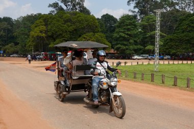 SIEM RIEP, CAMBODIA - NOVEMBER 5, 2019: Tuk Tuk driver bring tourists for Angkor Wat Tours in Cambodia clipart