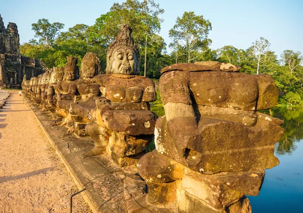 Angkor Thom 'un güney kapısı köprüsünde tanrı ve şeytan heykelleri var.