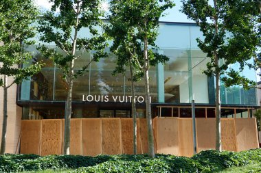 MANHASSET, NEW YORK - JUNE 7, 2020: Louis Vuitton store boards up as a precaution to prevent looting of the store in Americana Manhasset. Americana Manhasset is an upscale, open-air shopping center located in New York's suburb clipart