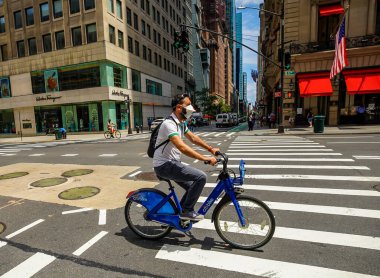 NEW YORK CITY - 16 Temmuz 2020: Manhattan şehir merkezindeki Columbus Circle yakınlarında yüz maskesi takan tanımlanamayan bisikletçi