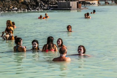 GRINDAVİK, ICELAND - 5 Temmuz 2016: Silika çamur maskeli jeotermal spa ziyaretçileri İzlanda 'daki ünlü Mavi Göl' de dinleniyor ve tazeleniyor. Mavi Göl İzlanda 'da en çok ziyaret edilen yerlerden biridir. 