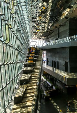 REYKJAVIK, ICELAND - 3 Temmuz 2020: Reykjavik, İzlanda 'daki Harpa konser salonu ve opera binasının içinde. İzlanda 'nın bazalt manzarasından esinlenilmiş belirgin renkli bir cam cephe.
