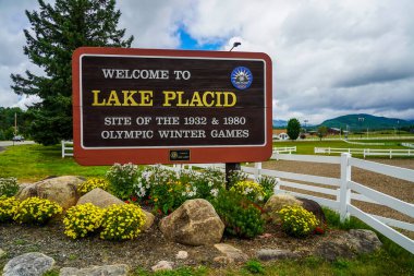 LAKE PLACID, New York - 3 AĞUSTOS 2020: 1932 ve 1980 Adirondack Dağları 'ndaki Olimpiyat Kış Oyunları' na ev sahipliği yapan Placid Gölü 'ndeki Hoş Geldiniz Tabelası, ABD' nin kuzeyinde.