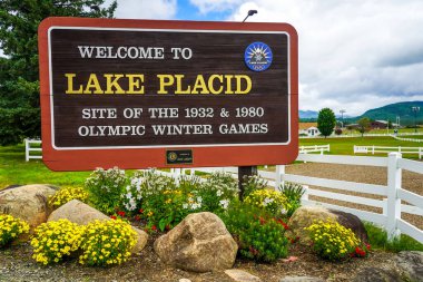 LAKE PLACID, New York - 3 AĞUSTOS 2020: 1932 ve 1980 Adirondack Dağları 'ndaki Olimpiyat Kış Oyunları' na ev sahipliği yapan Placid Gölü 'ndeki Hoş Geldiniz Tabelası, ABD' nin kuzeyinde.