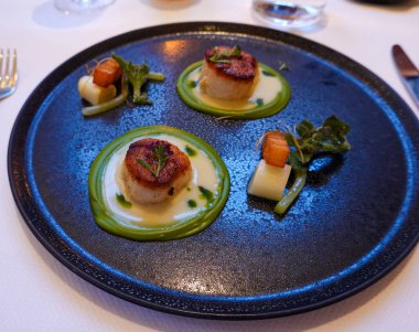 Gurme restoranında servis edilen kurutulmuş deniz tarağı tabağı.