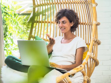 Salıncak koltukta oturan mutlu kadın, rahatla ve tatil konseptini kullan