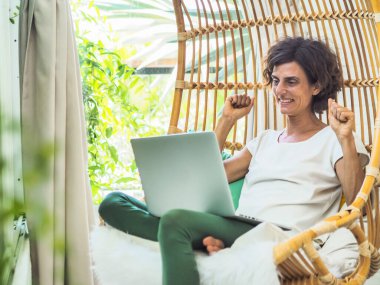 Salıncak koltukta oturan mutlu kadın, rahatla ve tatil konseptini kullan