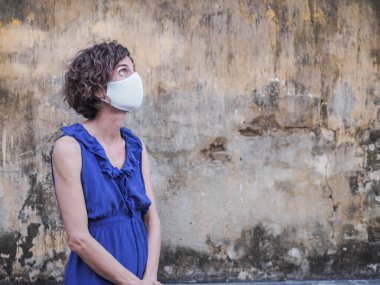 Koruyucu maske ve mavi elbise giyen kadın, koronavirüs salgını ve karantina konsepti