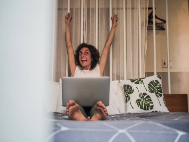 Evde, ofiste ve karantina konseptinde çalışan dizüstü bilgisayarlı bir kadın.