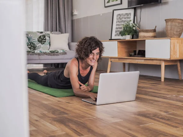 Glad Kvinna Använder Laptop Hemma Liggande Yogamattan — Stockfoto