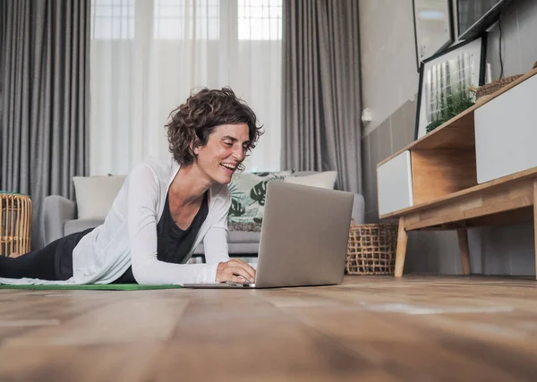 Glad Kvinna Använder Laptop Hemma Liggande Yogamattan — Stockfoto