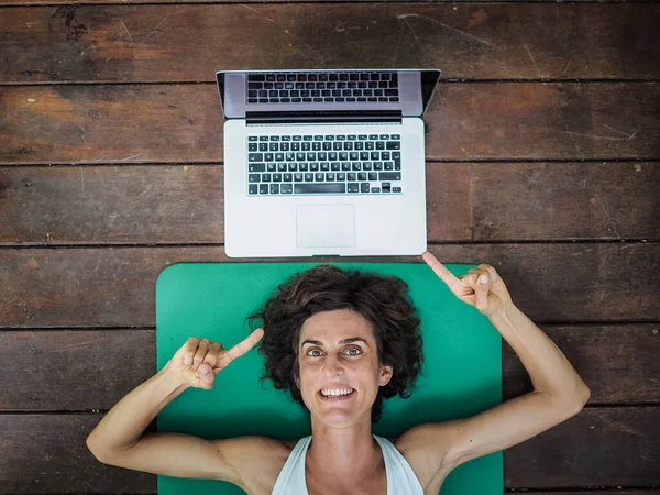 Leende Kvinna Liggande Yogamattan Golvet Med Laptop Bakom Huvudet — Stockfoto