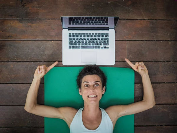 Emotionell Kvinna Liggande Yogamatta Golvet Med Laptop Bakom Huvudet — Stockfoto