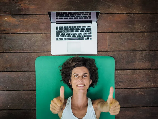 Leende Kvinna Liggande Yogamattan Golvet Med Laptop Bakom Huvudet — Stockfoto