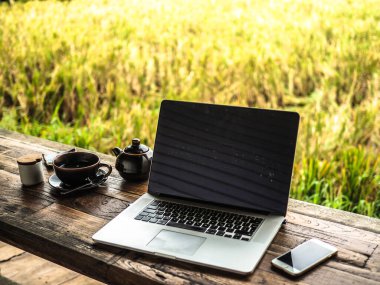 Laptop ve kahve fincanı açık masada.